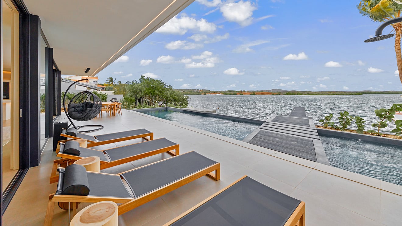 Waterfront sun loungers, private pool and terrace at The Wave Villa
